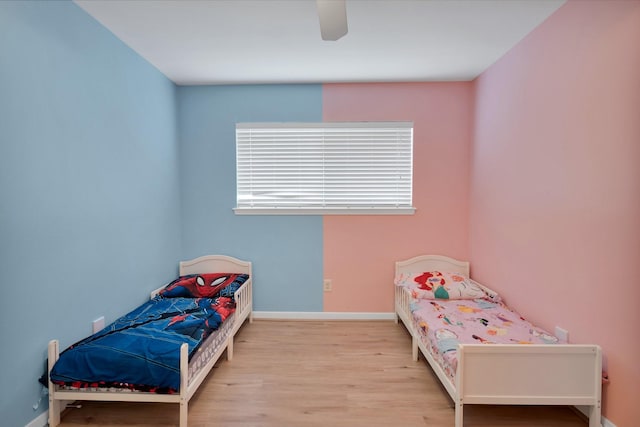 bedroom featuring ceiling fan, baseboards, and wood finished floors