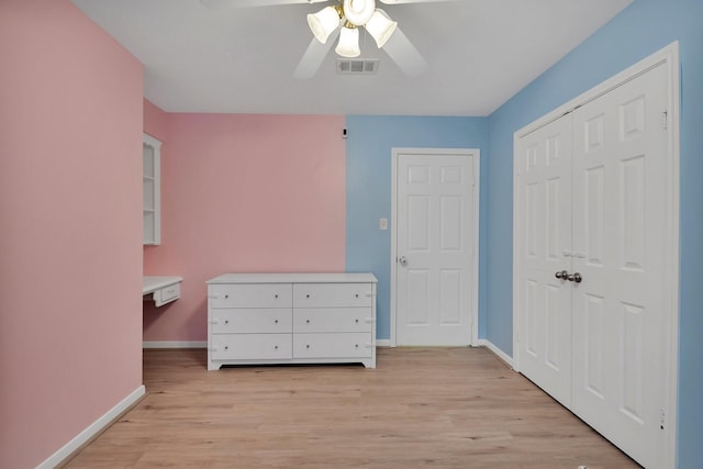 unfurnished bedroom featuring light wood finished floors, visible vents, baseboards, a closet, and a ceiling fan