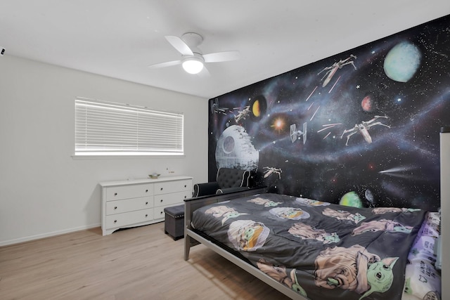 bedroom featuring a ceiling fan, baseboards, and wood finished floors