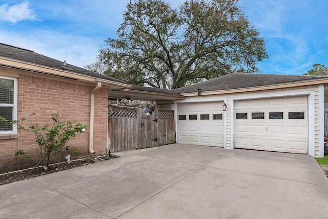 garage with fence and driveway