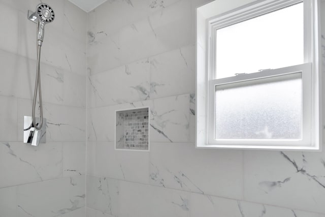 bathroom featuring a marble finish shower