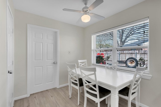 dining room with ceiling fan, baseboards, and light wood-style flooring