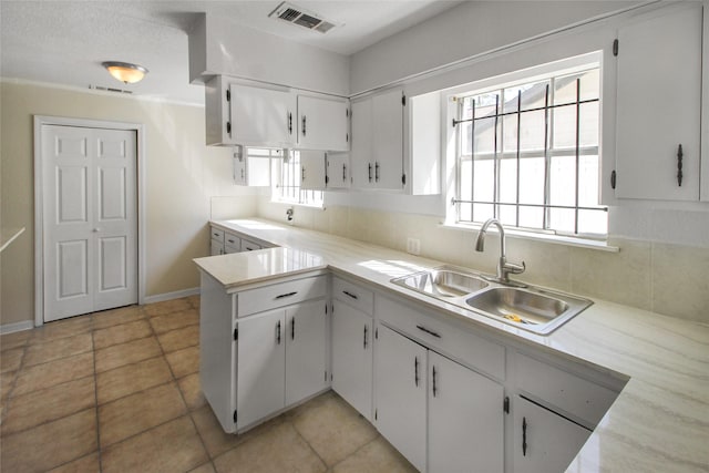 kitchen with a sink, visible vents, plenty of natural light, and white cabinetry