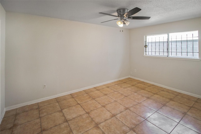 spare room featuring baseboards, a textured ceiling, and ceiling fan