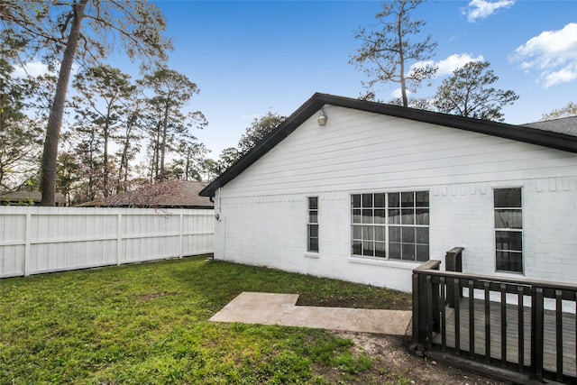 back of house with a lawn, fence private yard, and brick siding