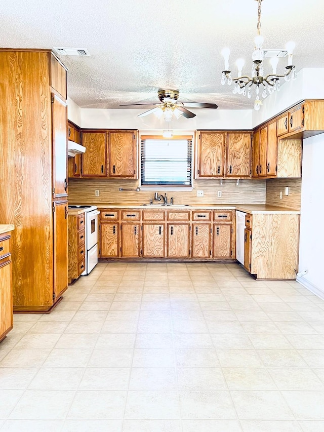 kitchen with white appliances, light countertops, visible vents, and a sink