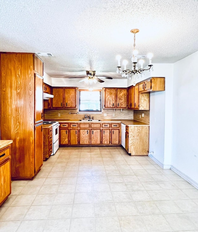 kitchen with electric range, brown cabinets, under cabinet range hood, a sink, and dishwasher