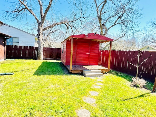 view of yard with an outdoor structure, a storage unit, and a fenced backyard