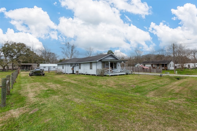 back of house featuring a yard and fence