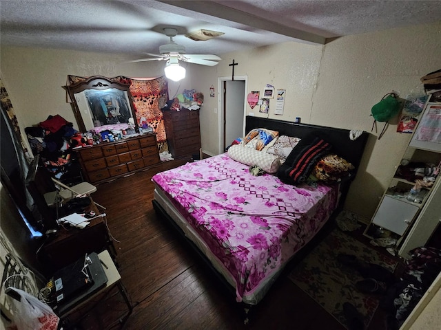 bedroom featuring hardwood / wood-style floors, a ceiling fan, a textured ceiling, beamed ceiling, and a textured wall