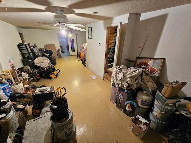 basement with a textured ceiling and a ceiling fan