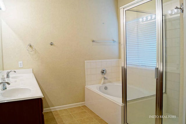 bathroom with tile patterned flooring, a garden tub, a stall shower, and a sink