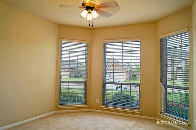 empty room with baseboards, ceiling fan, and carpet flooring