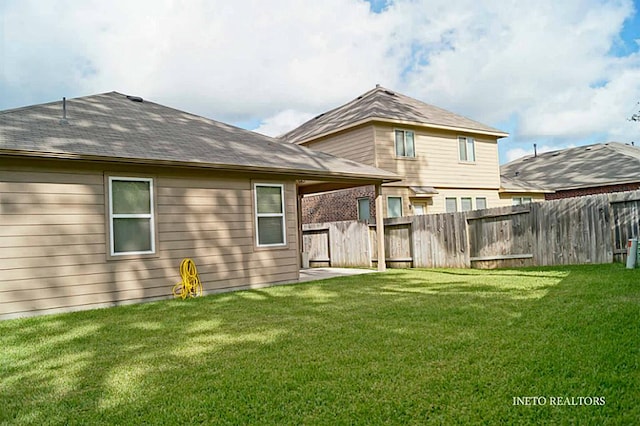 back of house featuring a yard and fence