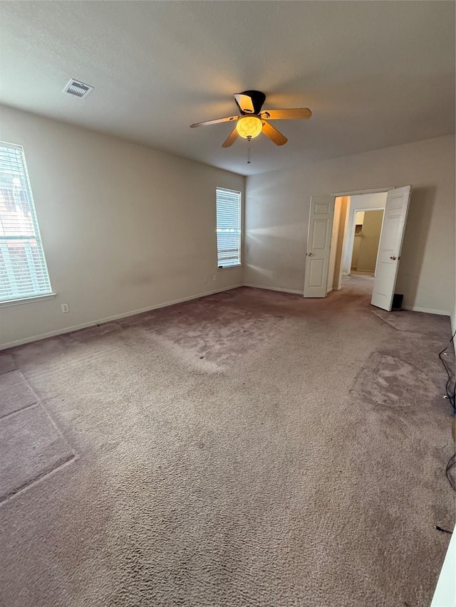 spare room featuring visible vents, baseboards, carpet, and a ceiling fan