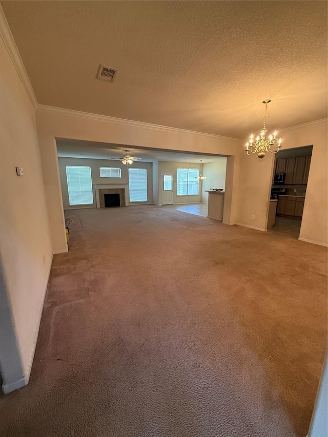 unfurnished living room featuring a notable chandelier, visible vents, carpet floors, and ornamental molding