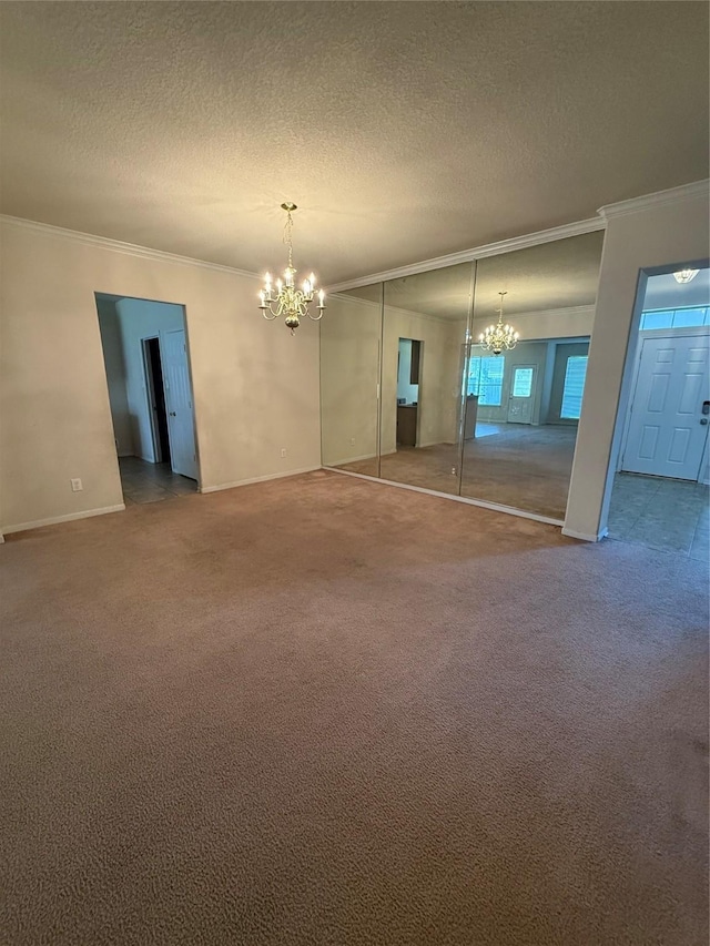 unfurnished room featuring crown molding, an inviting chandelier, and carpet floors