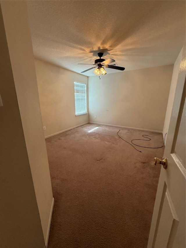 empty room featuring baseboards, a textured ceiling, ceiling fan, and carpet flooring