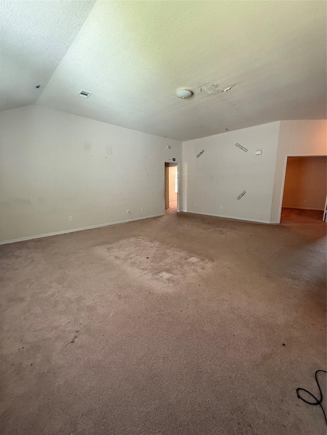 unfurnished room featuring visible vents, carpet flooring, a textured ceiling, and vaulted ceiling