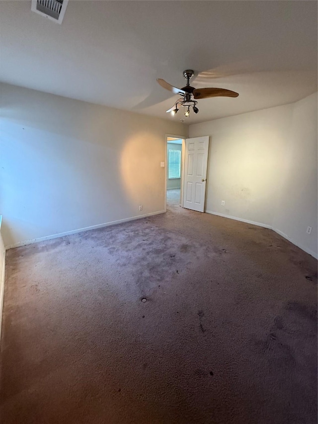 unfurnished room with a ceiling fan, visible vents, carpet floors, and baseboards