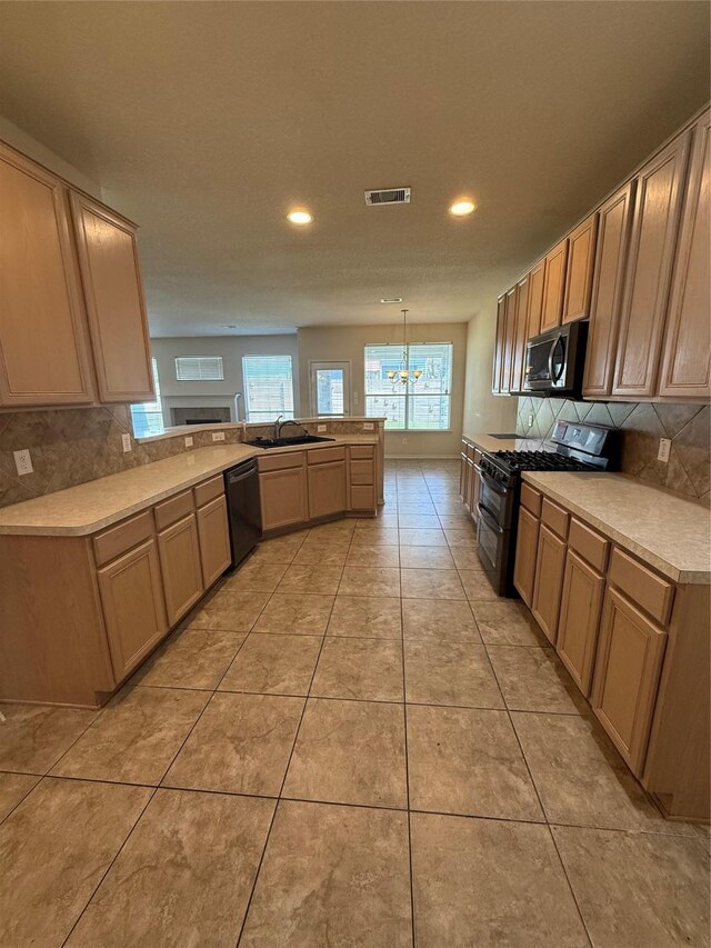 kitchen featuring visible vents, a peninsula, range with two ovens, a sink, and stainless steel microwave