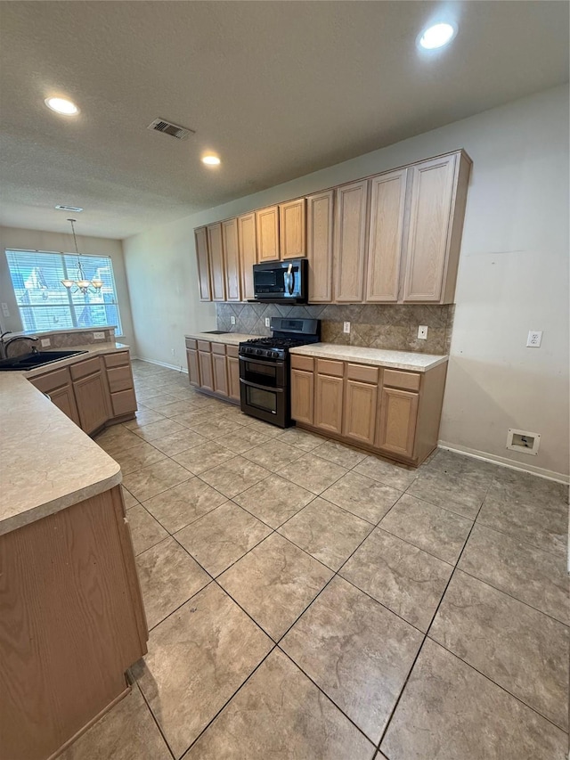 kitchen featuring visible vents, a sink, black microwave, range with two ovens, and decorative backsplash