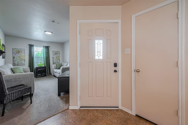 entryway featuring visible vents, baseboards, and carpet flooring