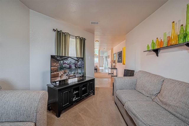 living area with visible vents and light colored carpet