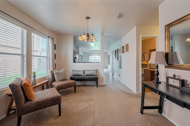 interior space with an inviting chandelier, carpet, visible vents, and baseboards