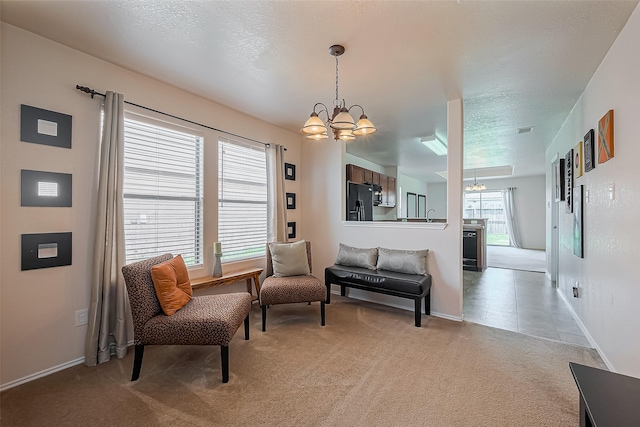 living area featuring a chandelier, plenty of natural light, a textured ceiling, and light carpet