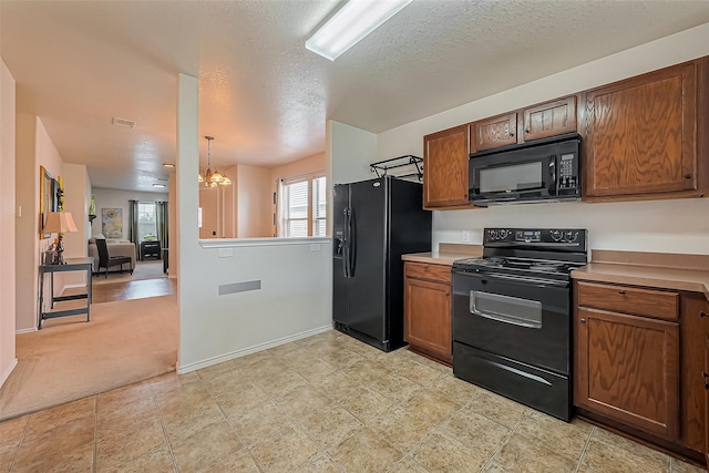 kitchen featuring brown cabinets, black appliances, light countertops, and an inviting chandelier