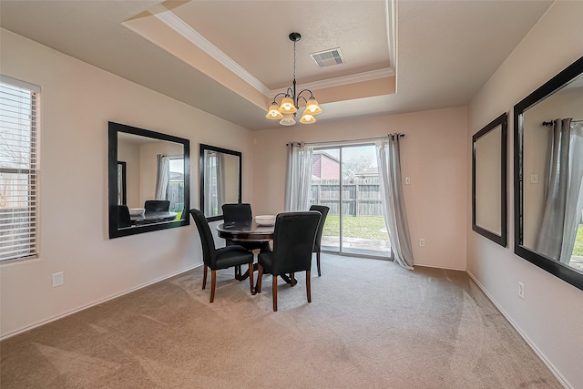 dining space featuring visible vents, crown molding, light carpet, a raised ceiling, and a notable chandelier