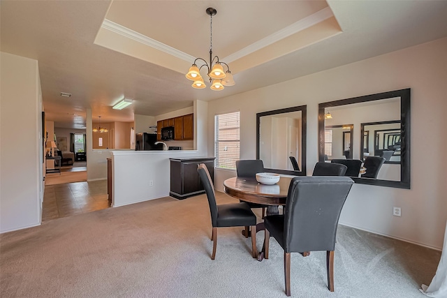 dining area with a tray ceiling, light carpet, a chandelier, and ornamental molding