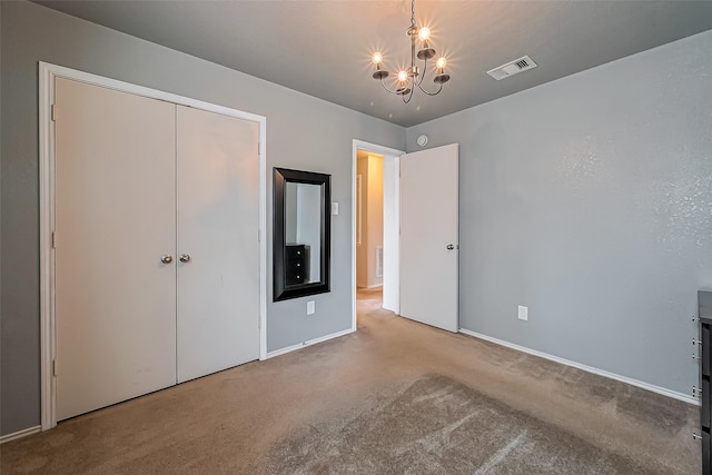 unfurnished bedroom with visible vents, baseboards, carpet, a closet, and a notable chandelier