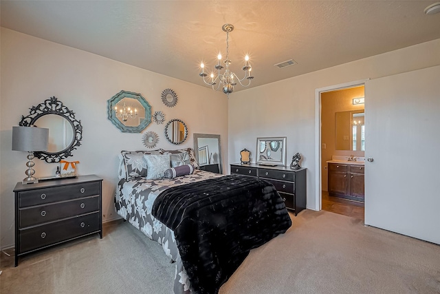 bedroom featuring visible vents, light carpet, a sink, ensuite bath, and a chandelier