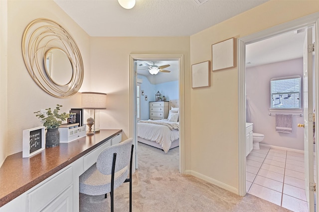 corridor featuring light tile patterned flooring, light colored carpet, and baseboards