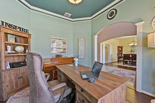 home office with visible vents, wood finished floors, arched walkways, an inviting chandelier, and crown molding