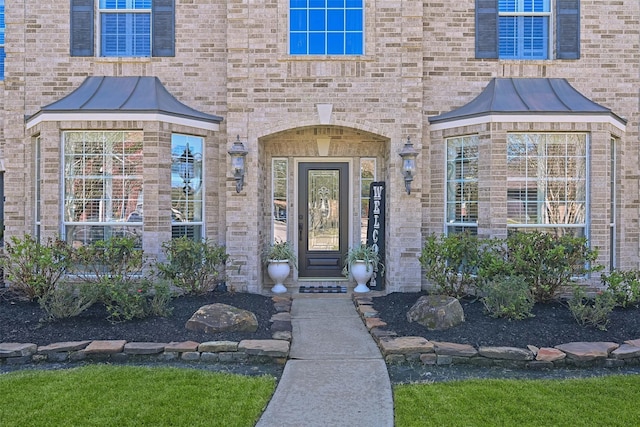 doorway to property featuring brick siding