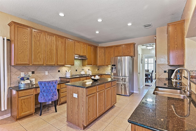 kitchen featuring visible vents, a sink, under cabinet range hood, stainless steel appliances, and light tile patterned floors