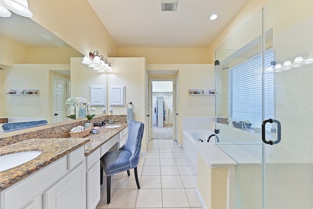 ensuite bathroom featuring visible vents, double vanity, a sink, a shower stall, and tile patterned floors