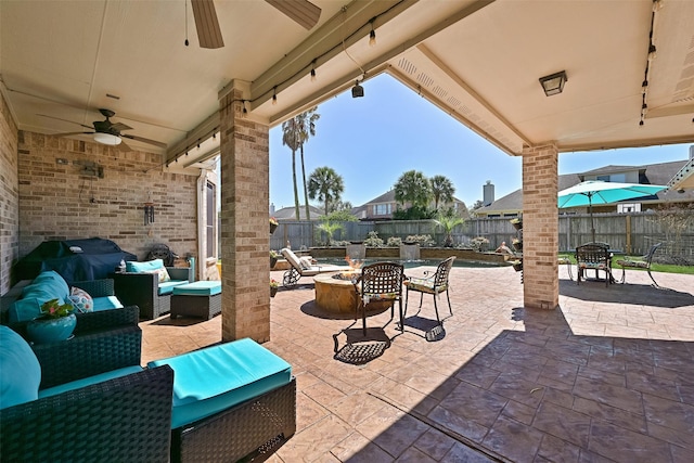 view of patio with an outdoor living space with a fire pit, a fenced backyard, and a ceiling fan