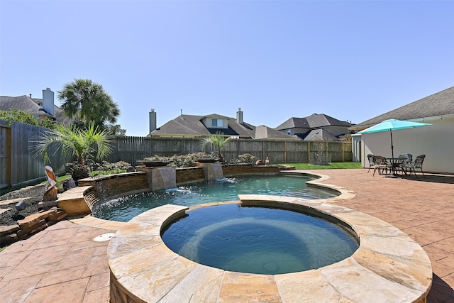 view of pool featuring a patio area, a pool with connected hot tub, and a fenced backyard