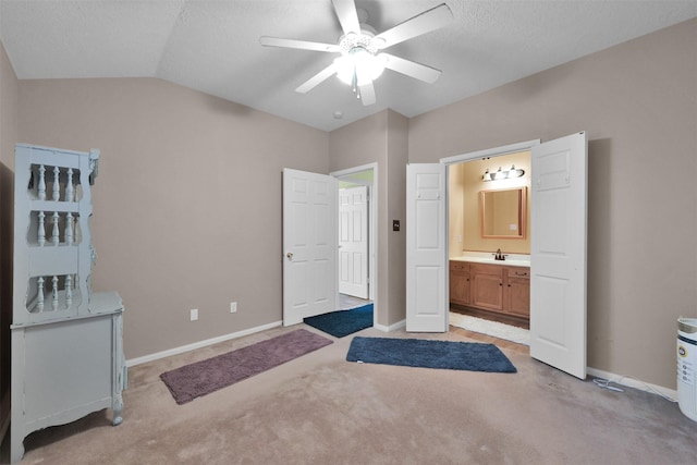 bedroom with ensuite bath, vaulted ceiling, baseboards, and light carpet