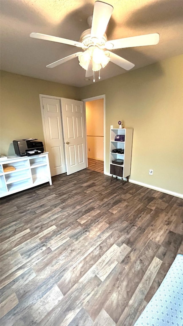 unfurnished bedroom with baseboards, wood finished floors, and a ceiling fan