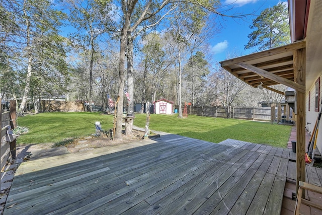 wooden terrace with a yard, a shed, a fenced backyard, and an outdoor structure