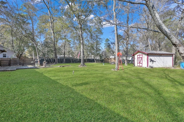 view of yard featuring a fenced backyard, a storage unit, and an outdoor structure