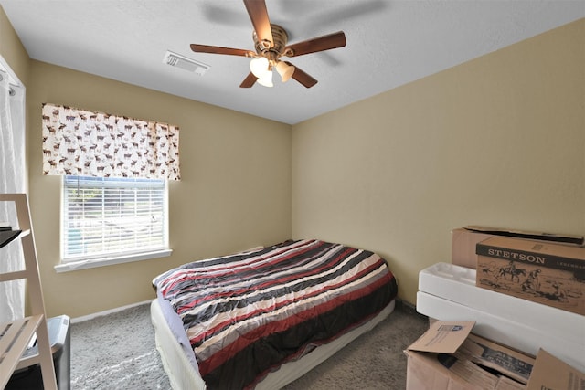 carpeted bedroom with visible vents, baseboards, and ceiling fan