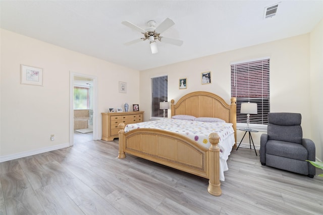 bedroom featuring visible vents, baseboards, ceiling fan, light wood-style floors, and ensuite bathroom