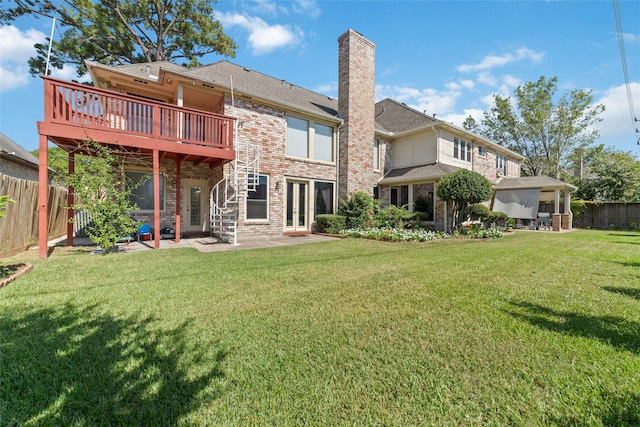 back of house with a fenced backyard, a yard, brick siding, a chimney, and a patio area