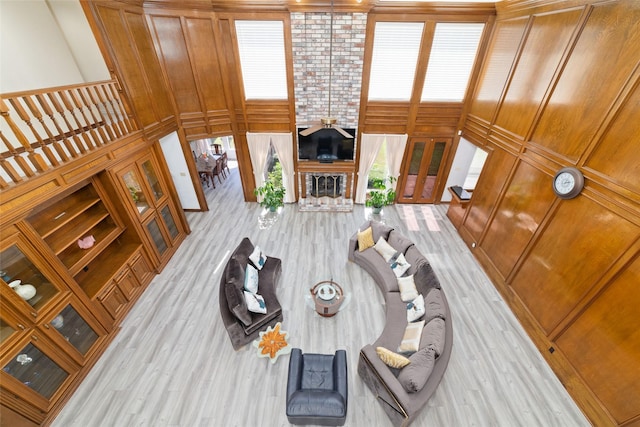 living room featuring wood finished floors, a towering ceiling, and a ceiling fan